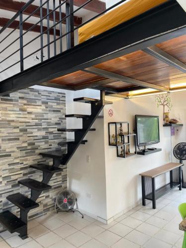 a staircase in a living room with a stone wall at Vacaciones Playa Club Casa Blanca Same Esmeraldas in Same