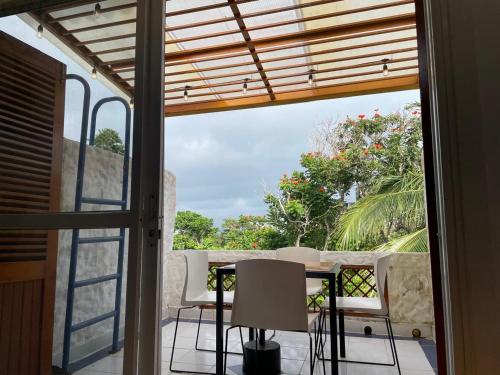 a room with a table and chairs on a balcony at Vacaciones Playa Club Casa Blanca Same Esmeraldas in Same