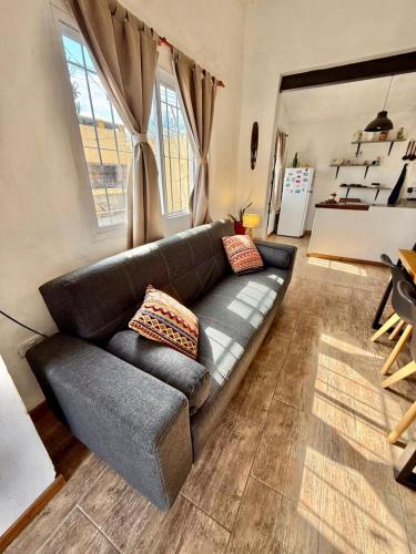 a living room with a black couch and some windows at El Satélite in Cordoba
