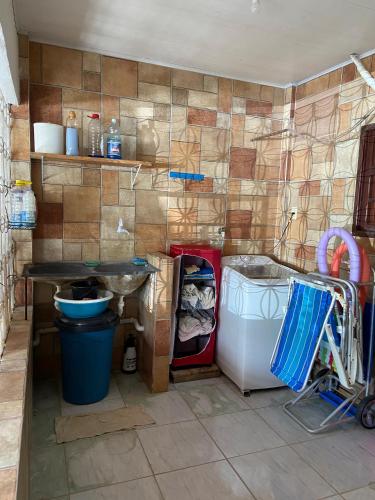 a kitchen with a sink and a washing machine at Refúgio do Tio em Jacumã in Conde