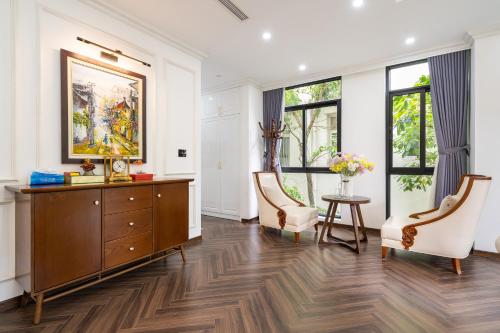 a living room with a dresser and two chairs at Lumiere Villa Splendora An Khánh in Vân Lũng