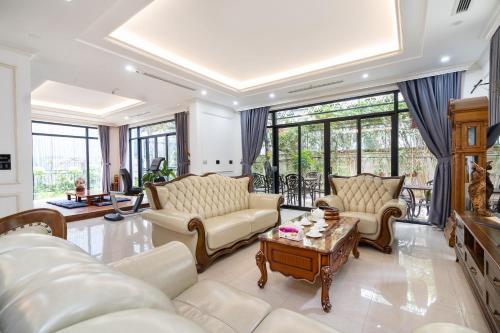 a living room with couches and a table at Lumiere Villa Splendora An Khánh in Vân Lũng