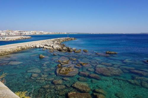 a beach with rocks and the blue water at Dar Carthage Hergla in Hergla