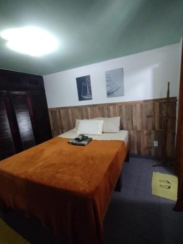 a bedroom with a bed with a brown blanket on it at Recanto da Árvore Suítes e Café in Arraial do Cabo
