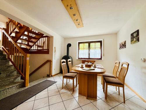 a dining room with a table and chairs and a staircase at Ins Scholze große und kleine Ferienwohnungen in Albersbach in Rimbach