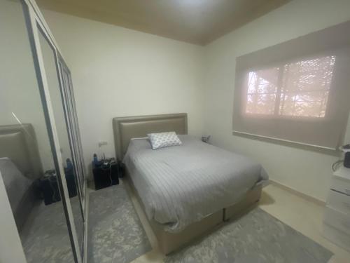 a small bedroom with a bed and a window at Agafay Olivium 