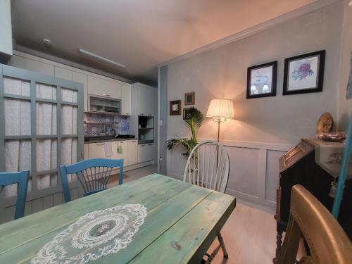 a dining room with a green table and chairs at 2층단독바닷가옥상주택 in Busan