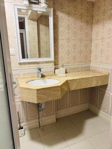 ein Badezimmer mit Waschbecken und Spiegel in der Unterkunft Erik Guest House in Bordschomi