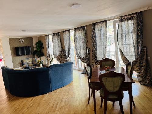 ein Wohnzimmer mit einem blauen Sofa und einem Tisch in der Unterkunft Erik Guest House in Bordschomi