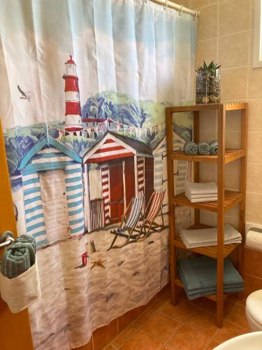 a bathroom with a shower curtain with a lighthouse at Alpha Five in Pissouri