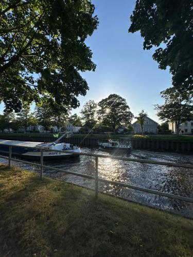 a boat is docked next to a river at Uferresidenz Altbau mit Kanalblick und Parkplätzen in Oldenburg
