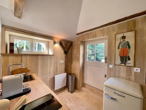 eine Küche mit Theke und Kühlschrank und einem Fenster in der Unterkunft Relais des Hautes Roches in Fondettes