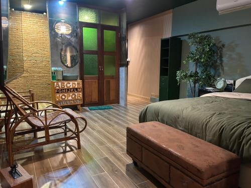 a bedroom with a bed and a chair and a door at The oasis on 8 in Bangkok