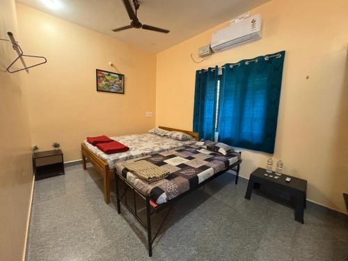 a bedroom with a bed and a ceiling fan at Areca Nest in Gokarna