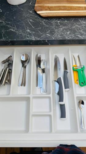 a white drawer filled with knives and utensils at Luxury Apartment in Böblingen in Böblingen