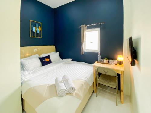 a small bedroom with a bed and a desk at Behomy Yume Residence in Jakarta