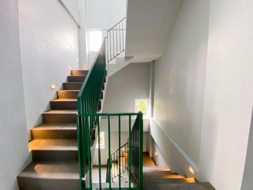 a staircase in a house with green railings at Behomy Yume Residence in Jakarta