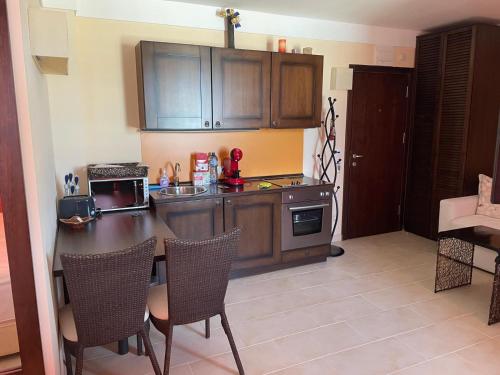 a kitchen with wooden cabinets and a table and chairs at Beachfront Apartment Oasis VIP Club in Sunny Beach
