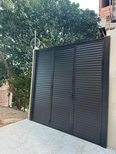 a black garage door on the side of a building at Studio Gilberto Machado in Cachoeiro de Itapemirim