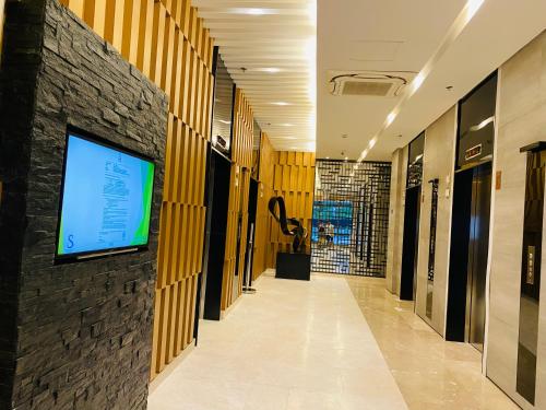 马尼拉Condotel at S Residences near SM MOA, SMX, Arena, NAIA Airport的走廊上,墙上有电视