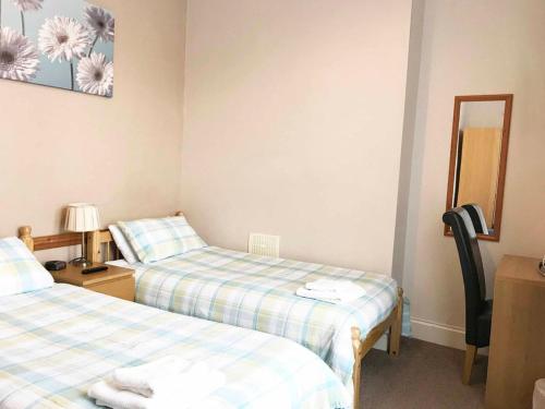 a room with two beds and a mirror at Esk Vale Guest House in Portsmouth