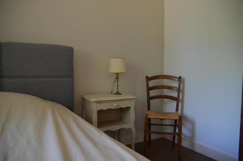 a bedroom with a bed and a chair and a lamp at Boederijgite in Corancy