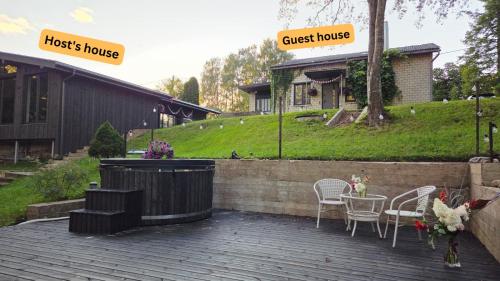 a patio with a table and chairs and a guest house at White Hill's Nest in Zvejniekciems