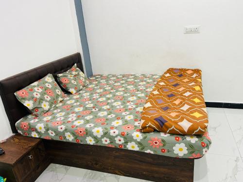 a bed in a room with flowers on it at Hotel Sanskar in Dodi