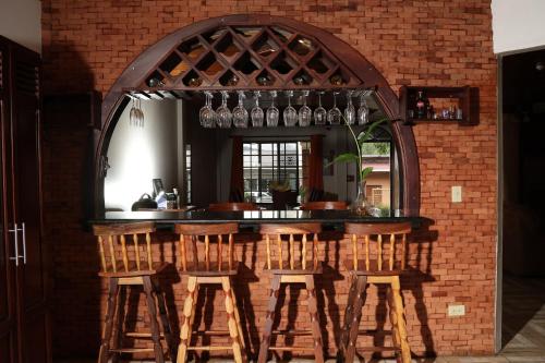 a bar with wooden stools and a brick wall at Novus Stay Boquete in Los Naranjos