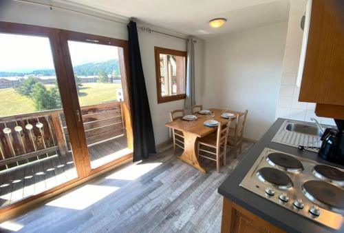 a kitchen with a table and a large window at Les Chalets De Superd Bleuet - 2 Pièces pour 6 Personnes MAE-8844 in Le Dévoluy