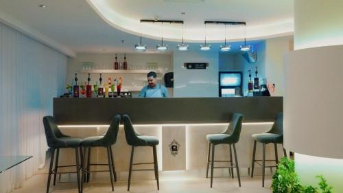 a man standing behind a bar with stools at Casablanca Elite in Jeddah