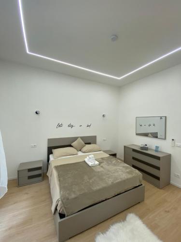 a white bedroom with a bed and a tv at Mare Montenotte in Savona