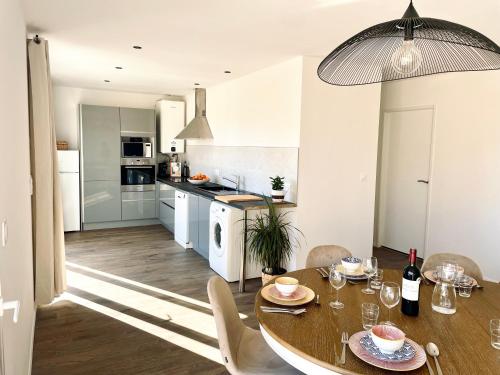 a kitchen and dining room with a table and chairs at Maison climatisée 3 chambres avec jardin in Pontenx-les-Forges