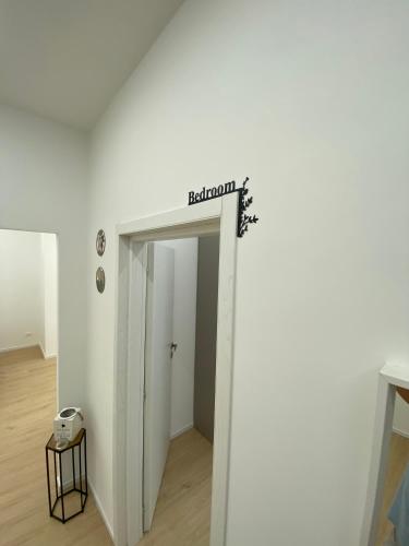 a white hallway with a sign that reads bathroom at Mare Montenotte in Savona