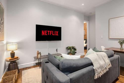 a living room with two couches and a tv at Trendy Nolita Stay Walk to SoHo & Little Italy in New York