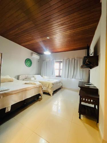 a bedroom with two beds and a wooden ceiling at Vila Do Pescador in Barra Grande