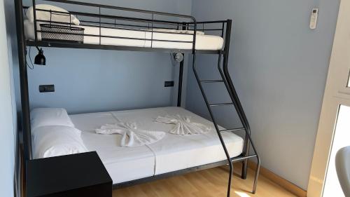 a bunk bed with white sheets and a ladder at Apartamento Ginette SunBeach in Salou