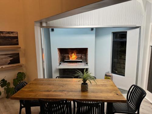a dining room with a table and a fireplace at Wilderness deckhouse. views!/sun/sea/river/kayaks in Wilderness