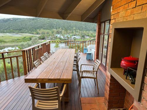 a wooden table and chairs on a deck at Wilderness deckhouse. views!/sun/sea/river/kayaks in Wilderness