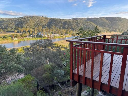 a balcony with a view of a river and mountains at Wilderness deckhouse. views!/sun/sea/river/kayaks in Wilderness