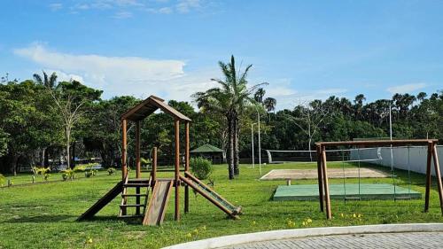 a park with a playground with a swing set at Beira do rio com píer e piscina in Barreirinhas