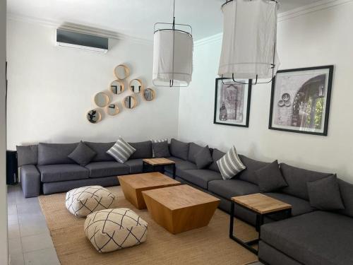 a living room with a blue couch and tables at Villa Roseaux heated pool Marrakech in Najem