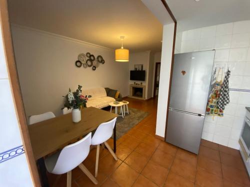 a kitchen and living room with a table and a refrigerator at Sweet home in Entroncamento