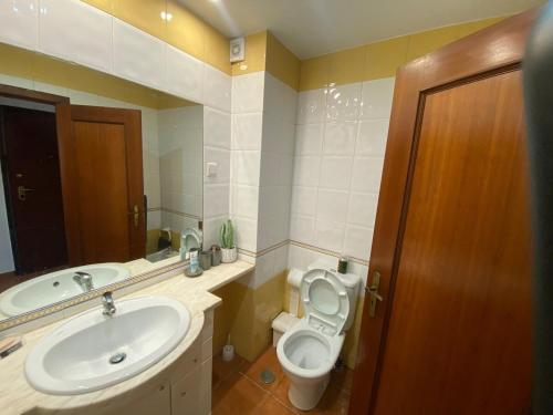 a bathroom with a sink and a toilet and a mirror at Sweet home in Entroncamento