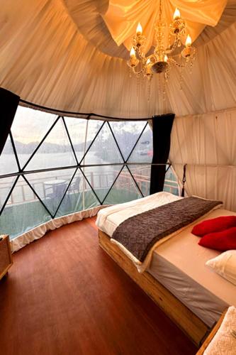 a bedroom with a bed and a large window at Afton Boba 2 Sikunir in Kejajar