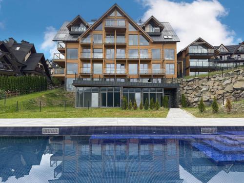 a large house with a swimming pool in front of it at Stone Suite Zakopane in Zakopane