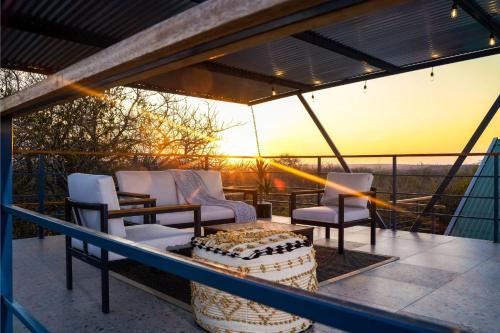 a patio with chairs and a table on a balcony at Amani Luxury Villa Marloth Park in Marloth Park