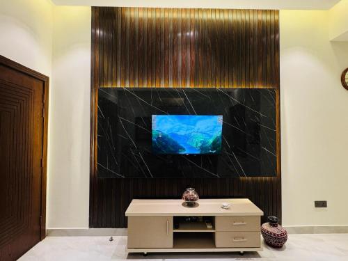 a living room with a tv on a wall at Anayah Fam Rental in Rawalpindi