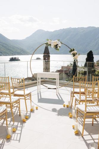 a table and chairs on a deck with a view of the water at Santa Boka in Perast