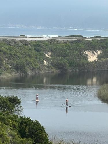 two people are standing in a body of water at Wilderness deckhouse. views!/sun/sea/river/kayaks in Wilderness